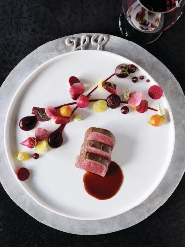 a plate of food with a piece of meat on it at Huka Lodge in Taupo