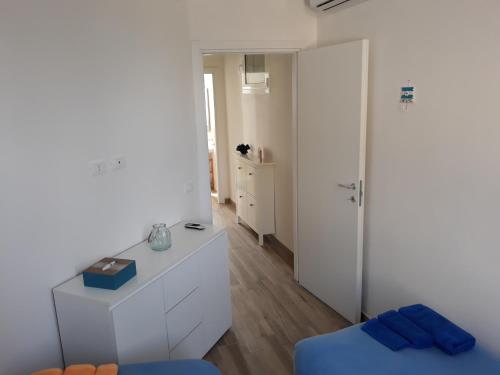 um quarto branco com uma cama azul e um armário branco em Villa Falconara em Noto Marina