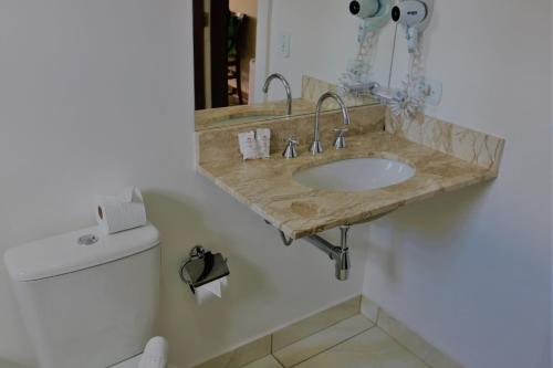 a bathroom with a sink and a toilet at Hotel Bologna in Campos do Jordão
