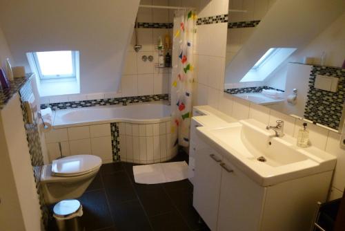 a bathroom with a sink and a toilet and a tub at Zum Löwen in Bad Homburg vor der Höhe