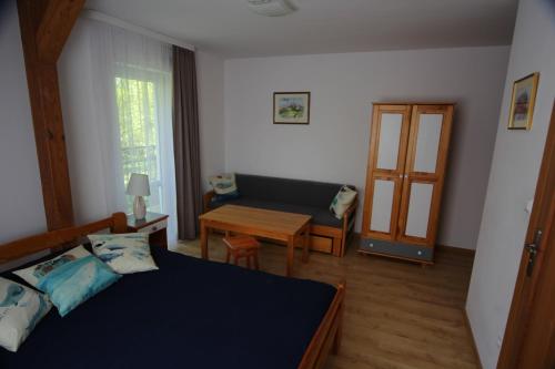 a bedroom with a bed and a couch and a table at Willa Nauta in Dębki