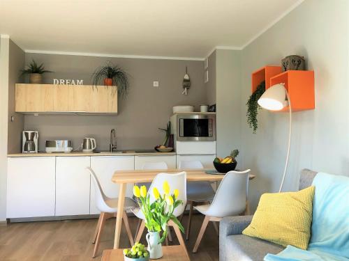 a kitchen and living room with a table and chairs at Apartament MOMENTUM in Trzęsacz