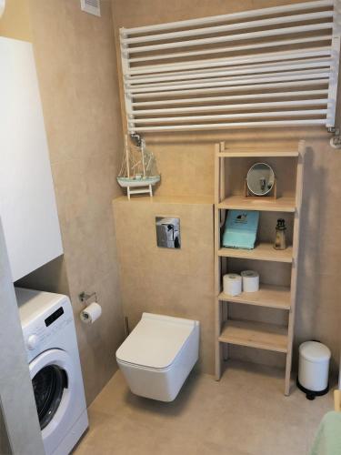 a bathroom with a toilet and a washing machine at Apartament MOMENTUM in Trzęsacz