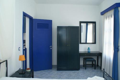 a blue door in a bedroom with a desk and a desk at Villa Antoniadis in Platis Yialos Sifnos