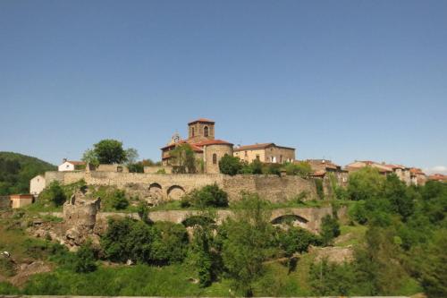 uma aldeia no topo de uma colina com um castelo em Ermitage Saint Vincent B&B em Vieille-Brioude