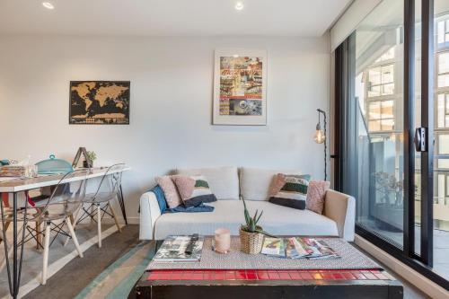 a living room with a couch and a table at LUXURIOUS RIVERSIDE RESORT STYLE APARTMENT☆POOL☆SPA☆GYM☆ROOFTOP WITH CITY VIEWS in Melbourne