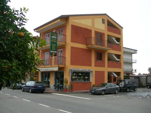 a building with cars parked in front of it at Caffè Nuovo 2 Holiday Rooms in Trappitello