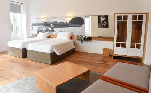 a bedroom with two beds and a coffee table at Internacional Azores Boutique in Horta