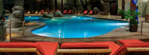 une grande piscine entourée de chaises rouges. dans l'établissement Bally's Lake Tahoe Casino Resort, à Stateline