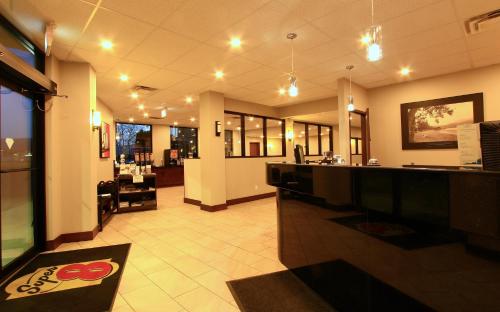a restaurant with a bar in the middle of a room at Super 8 by Wyndham Kelowna BC in Kelowna