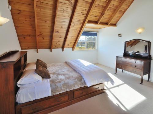 a bedroom with a bed and a dresser and a television at The Residence @ Elbourne Wines in Lovedale
