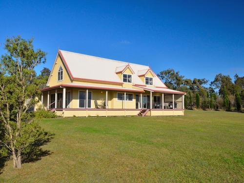 a large yellow house with a large yard at The Residence @ Elbourne Wines in Lovedale