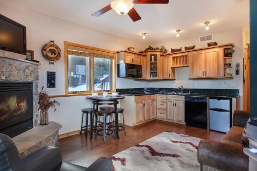 una cucina con armadi in legno, tavolo e camino di Lookout Mountain 27B Condo a Estes Park
