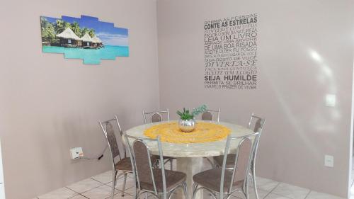 comedor con mesa y sillas en Residencial mar do norte, en Florianópolis
