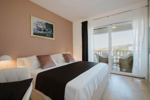 ein Schlafzimmer mit einem großen Bett und einem großen Fenster in der Unterkunft Villa Mia in Marina