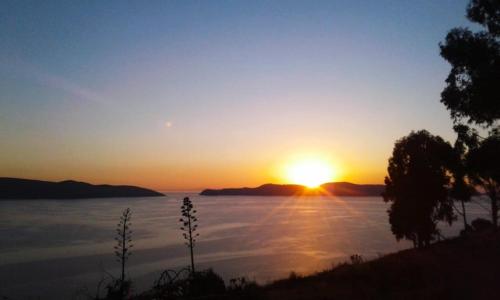 a sunset over a body of water at Hostal Qhana Pacha in Isla de la Luna