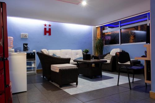 a living room filled with furniture and a red cross on the wall at Hotel H - Fabiola Adults Only in Mexico City