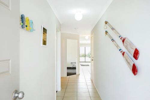 a hallway with white walls and a white stairway with a row ofiterraneaniterranean at Bayside - Aldinga Beach - C21 SouthCoast Holidays in Aldinga Beach