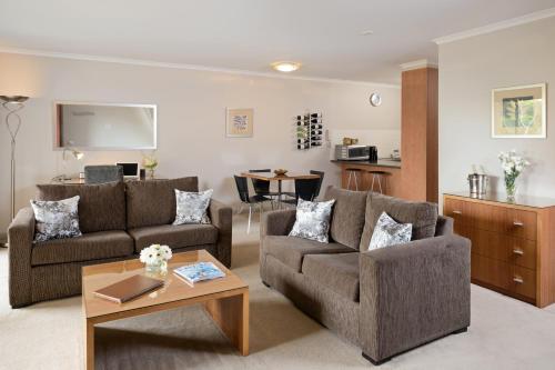 a living room with two couches and a table at Ringwood Royale in Ringwood