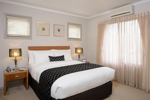 a bedroom with a large bed and a window at Ringwood Royale in Ringwood