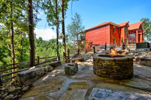 a fire pit in front of a red house at Greenbrier Estate Cabin in Pittman Center