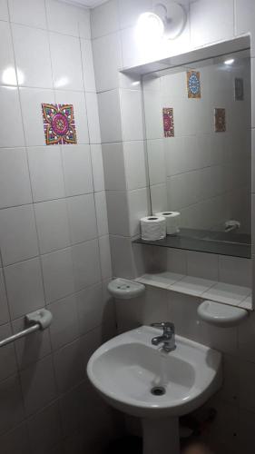 a white bathroom with a sink and a toilet at Hotel Florencia in Necochea