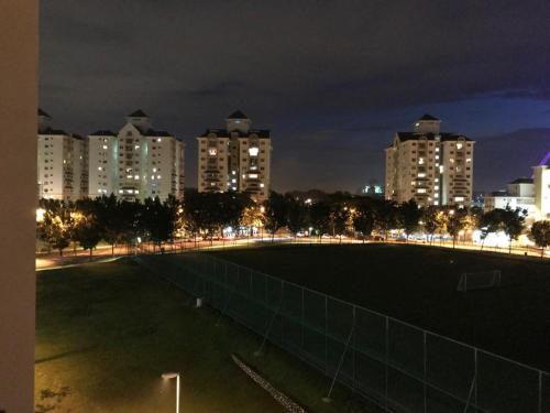 a soccer field in front of a city at night at Bayu TAMARA RESIDENCE PUTRAJAYA in Putrajaya