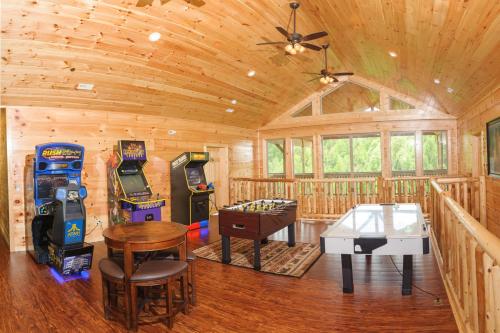 eine Holzhütte mit einem Tisch und Arcade-Spielen in der Unterkunft Foxwood Mansion Cabin in Pittman Center