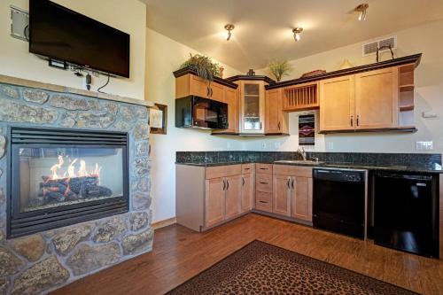 a kitchen with a fireplace with a tv on a wall at Mount Meeker 26B Condo in Estes Park