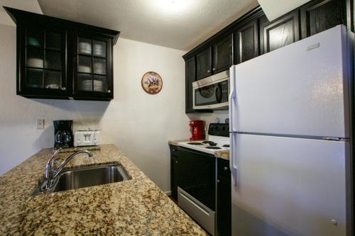 a kitchen with a sink and a white refrigerator at Chamonix Condo 94 Condo in Mammoth Lakes