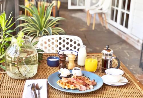a table with a plate of breakfast food on it at Motel Nomad in Cairns