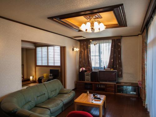 a living room with a couch and a television at Nakagawa's Cozy House in Sakai