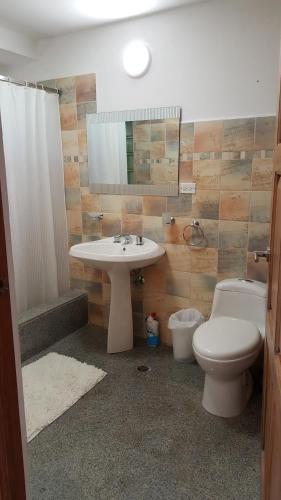 a bathroom with a sink and a toilet and a mirror at Gamboa Apartment Toucan y Studio Ñeque in Gamboa