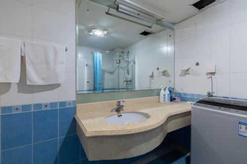 a bathroom with a sink and a mirror at Dalian Xiuzhu Mansion Apartment in Dalian