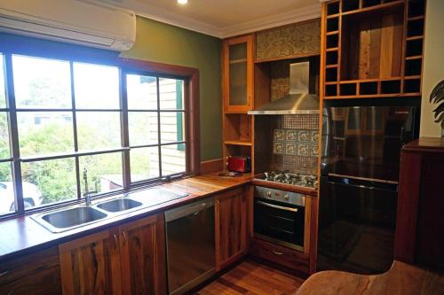 a kitchen with wooden cabinets and a sink and a window at Bridgefield Guest House in Margaret River Town