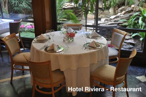 Hotel Solans Riviera في روزاريو: طاولة مستديرة مع قطعة قماش وكراسي بيضاء