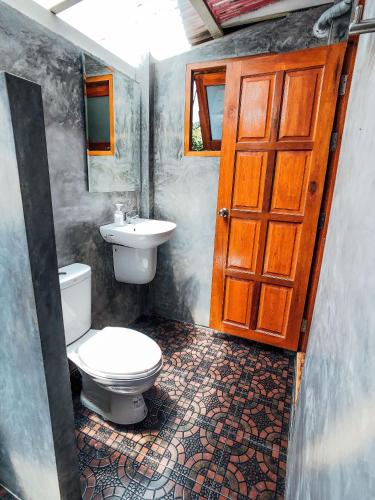 a bathroom with a toilet and a sink at Colorful Hut in Haad Pleayleam