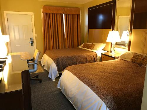 a hotel room with two beds and a desk with a chair at Cardinal Court Motel in Saint Thomas