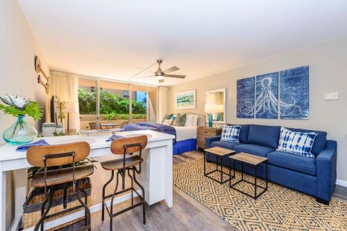 un salon avec un canapé bleu et un salon dans l'établissement Royal Kahana 119 Studio Condo, à Kahana