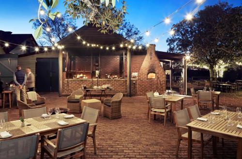 a restaurant with tables and chairs and lights at Spicers Hidden Vale in Grandchester