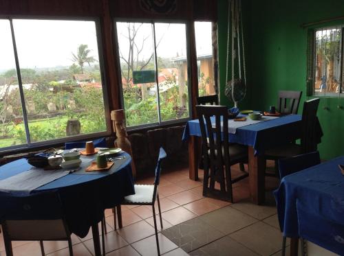 a dining room with two tables with blue tablecloths at Hotel Taura'a in Hanga Roa