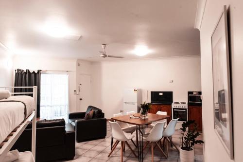 a room with a bed and a table and chairs at Motel Nomad in Cairns