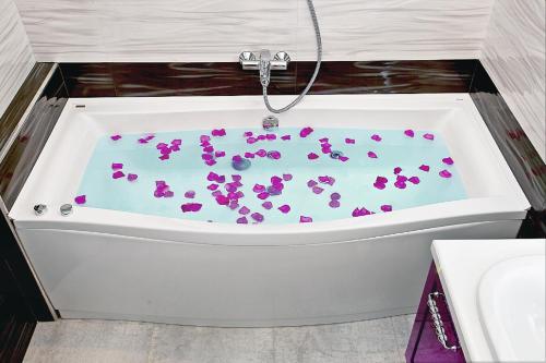 a bath tub with purple flowers in it at Beach & Beatles Apartments in Odesa