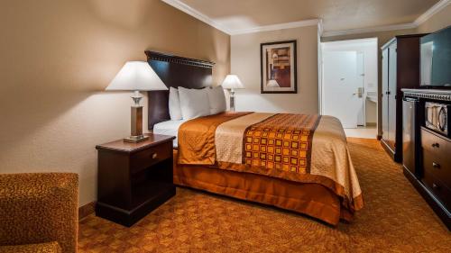 a hotel room with a bed and a chair at Lompoc Valley Inn and Suites in Lompoc