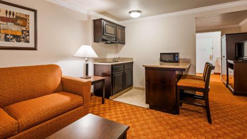 a living room with a couch and a desk and a kitchen at Lompoc Valley Inn and Suites in Lompoc