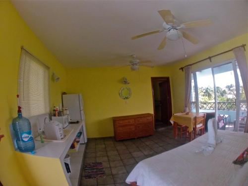 Un dormitorio con una cama y un ventilador de techo. en Sea Hawk Suites, en Isla Mujeres
