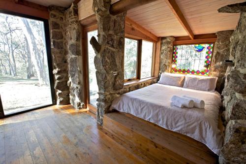 1 dormitorio en una cabaña de madera con cama y ventanas en Snowy Wilderness en Ingebyra
