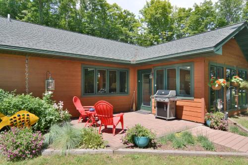 una casa con due sedie e una griglia su un patio di Namakagon Landing Condo a Cable