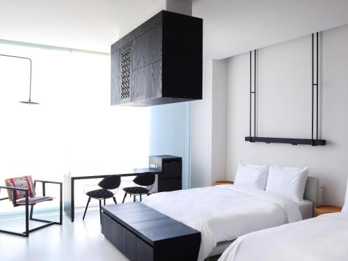 a bedroom with two beds and a table and chairs at The Place Tainan in Tainan