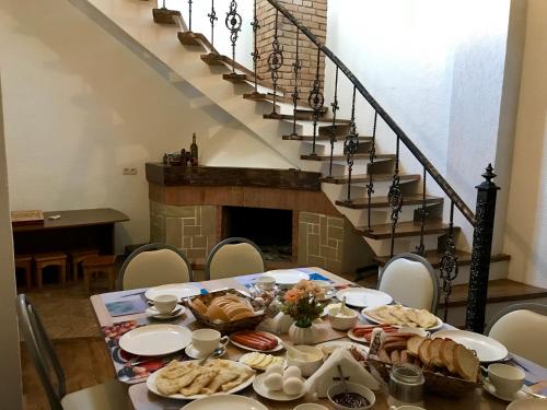 a table with food on it in a room with stairs at Golden Gate in Akhaltsikhe